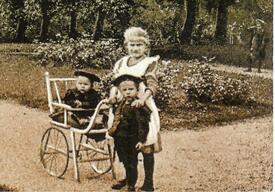 1909 Kindermädchen mit Kinderkarre und beaufsichtigten Kindern im Stadtpark der Stadt Wilster