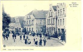 1901 Marktplatz Westseite - Tierschau in Wilster, festlich gekleidete Menschen flanieren auf der Westseite des Marktplatzes