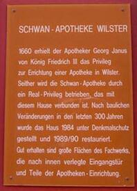1990 Informationsschild an der Schwan Apotheke am Kohlmarkt in der Stadt Wilster